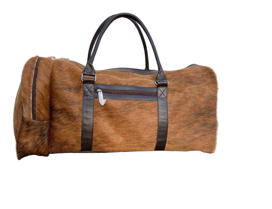 Brown duffel bag with black straps on a tiled floor