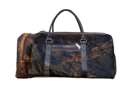 Brown leather duffel bag on a tiled floor with a stone wall background