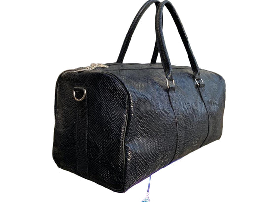 Black textured handbag on a reflective surface with a blurred background
